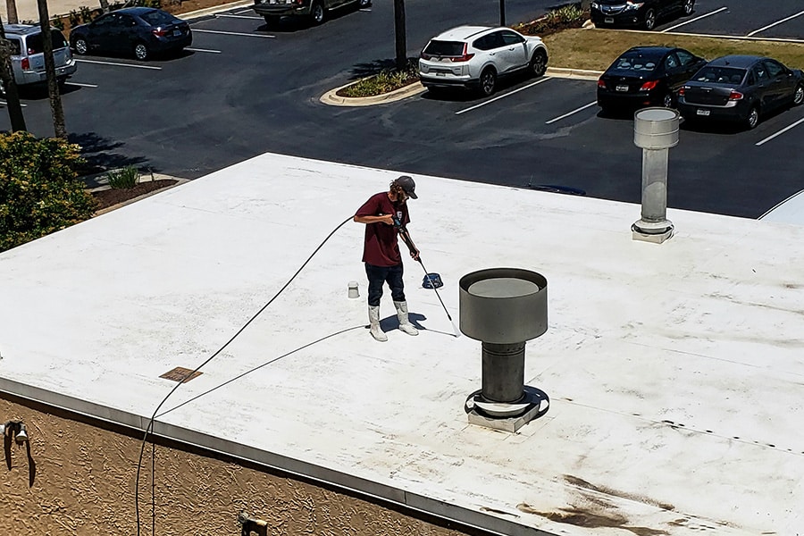 roofer performing maintenance to a commercial foam roof