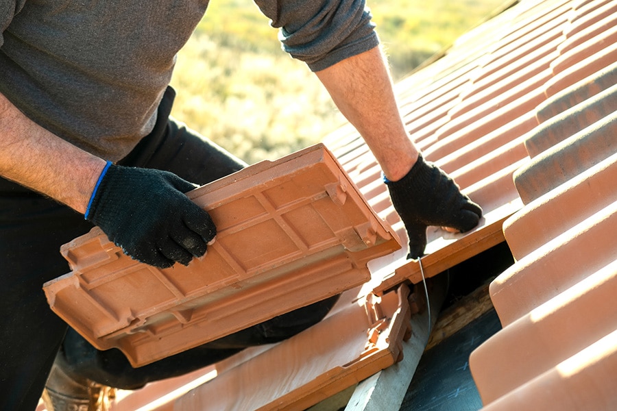 tile roofing professional examining underlayment