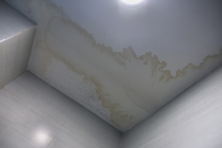 a roof that has developed a leak shows its damage by water spots on a ceiling